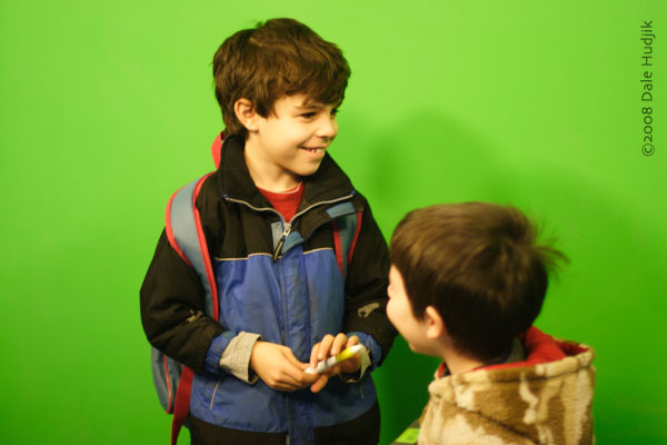 two boys in front of a green screen